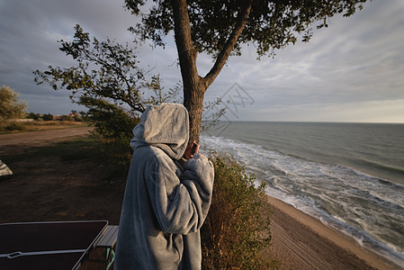 年轻女子用智能手机拍摄海日日落照片技术海景白色假期海滩屏幕旅行太阳女士电话图片