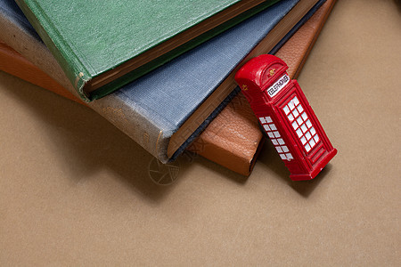 英国古典风格的红电话亭和书籍旁的红色电话亭背景图片