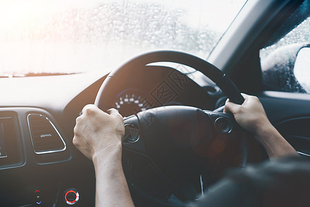 方向盘上的妇女手驾驶一辆有阳光背景的汽车车辆司机男人旅行交通商业控制板玻璃运动太阳图片