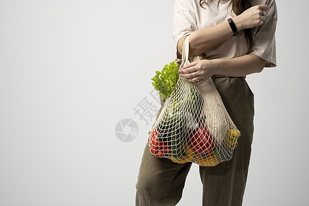 快乐的女人拿着可重复使用的棉质购物袋 里面装着杂货 面包和蔬菜 没有塑料的概念 零浪费 无塑料 可持续的生活方式图片