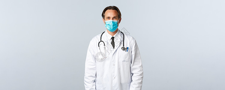 Covid19 预防病毒 医护人员和疫苗接种概念 身穿白大衣和医用口罩的中年专业治疗师在诊所听病人 在工作中听医生护理暴发保险实图片