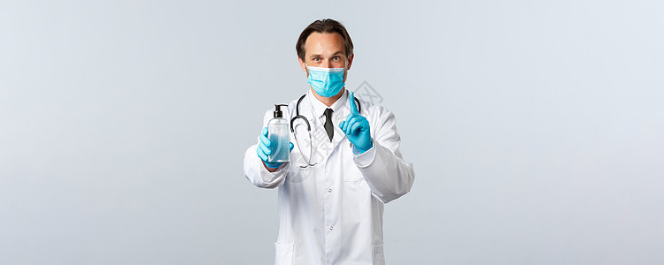 Covid19 预防病毒 保健工作者和接种疫苗概念 微笑医生解释使用手消毒剂的重要性 展示规则一 戴医疗面具和手套管子诊所洗手液图片
