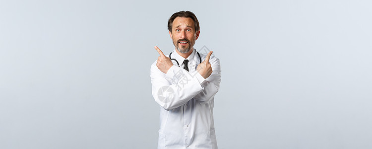 Covid19 冠状病毒爆发 保健工作者和大流行病概念 穿着白大衣的犹豫不安的男性医生 在变体上指手指侧角 要求帮助选择学院实验图片