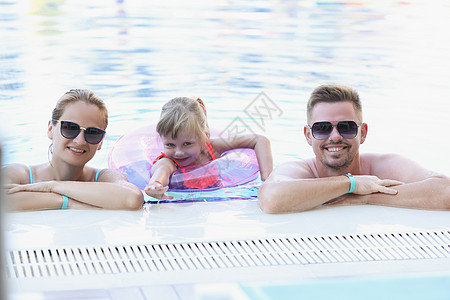 快乐的家庭在游泳池里合拍相照的喜悦家庭女孩父亲父母棕褐色冒充乐趣情绪假期旅行异国图片