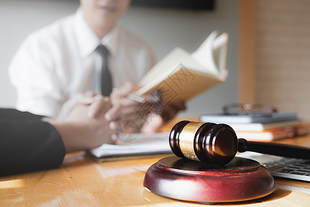 女商务人士和律师在办公室的木桌上用黄铜秤的律师书讨论 法律 法律服务 咨询 正义概念图片