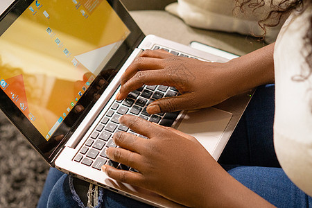 女手在笔记本电脑键盘上打字 黑皮肤的人在笔记本电脑上工作 手提电脑上的手的特写镜头图片