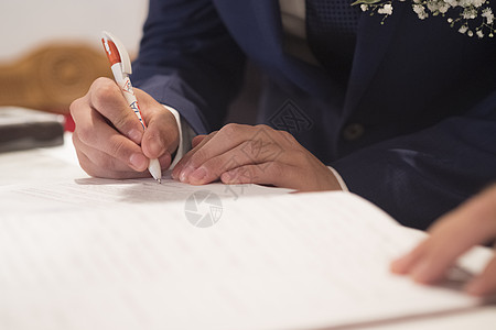 新郎在天主教婚礼上的签名登记簿上签字白色文档新婚派对仪式活动夫妻新娘夫妇教堂图片