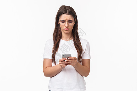 通讯 技术和生活方式概念 麻烦和困惑的年轻女性在阅读奇异信息 如看手机显示器一样皱眉惊心动脸 站在白种背景上站着女孩乐趣假期女朋图片