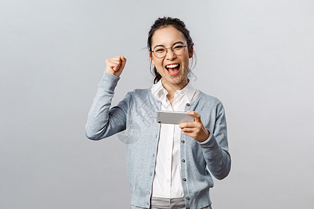 科技 在线和移动生活方式概念 在智能手机游戏中 欢欣快乐地胜利的亚洲女性赢得奖项或打分 握着电话 举起手来庆祝胜利幸福闲暇微笑女图片