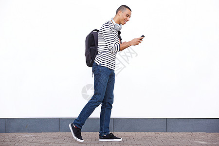 以白色墙壁看手机的年轻人行走和观看情况简图肖像图片