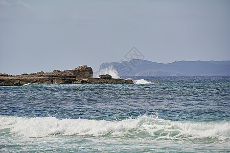 岸边的岩石被波浪撞击娱乐地平线天空海滩飞溅海洋冲浪边缘海岸线青色图片