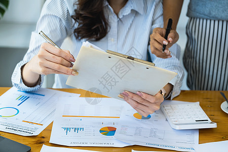 女企业家和同事们正在使用预算文件来计算当年最后一个季度的收入 以规划来年的金融投资电脑文档统计办公室写作银行帐户经理平衡工作图片