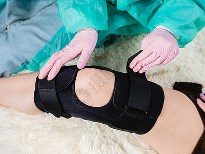 一名家庭医生在病人的膝盖上戴上黑色牙套骨科诊所瘙痒理疗疾病手套伤口女士护士女性图片