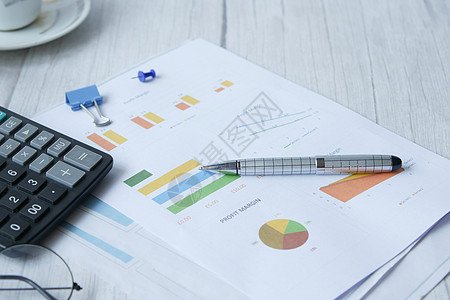 表格上的财务图表 计算器和注纸桌子金融工作数据文档文书报告商业背景图片