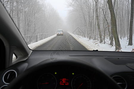 危险的冬季 路上有雪 从司机的角度看汽车内部恶劣天气下的危险交通窗户街道季节暴风雪车辆薄雾城市运输大灯驾驶图片