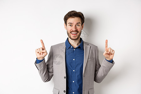 穿着西装的兴奋的幸运商务人士竖起手指 笑得开心 展示很酷的广告 站在白色背景上情绪办公室男人男性成人商务生活企业家胡子快乐图片