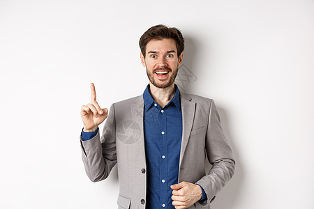 激动的商务人士在西装上投出好主意 在eureka牌上举起手指和看笑脸 说建议 站在白色背景上胡子推销员成功快乐企业家工作成人套装图片