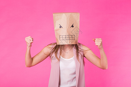 消极情绪的观念  愤怒的女人 脸上有纸袋符号男人姿势隐藏表情面具权威面部刺激顾客图片