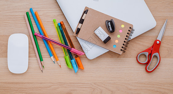 回到学校概念与学校用品膝上型电脑 书本 笔 mouse和木制桌上的彩色铅笔图片