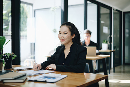 女商务人士在办公室与在后台工作的商务人士一起分析技术价格图表和指标 帐户或存钱或保险概念抵押退休支付电脑统计基金贷款会计预算团队图片