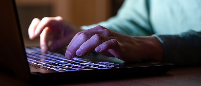 那个女孩晚上在笔记本电脑上工作 手关紧人士开发商游戏商务房子互联网桌子紫色程序员技术图片