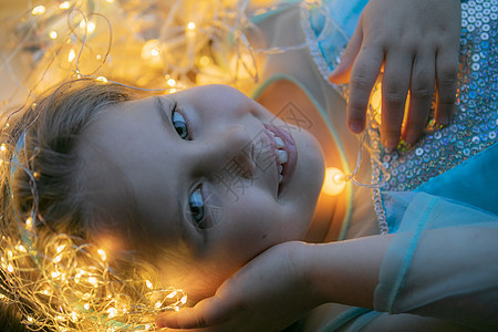带圣诞灯的小女孩魔法假期庆典童年卷发孩子黑发蜡烛展示装饰图片