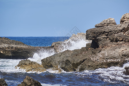 岸边的岩石被波浪撞击海浪海岸线海洋天空冲浪海景气泡支撑地平线娱乐图片