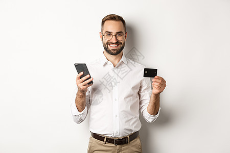 商业和在线支付 微笑的男性企业家用信用卡和手机购物 站在白色背景上老板横幅促销商务金融成功企业家男人工作室广告图片