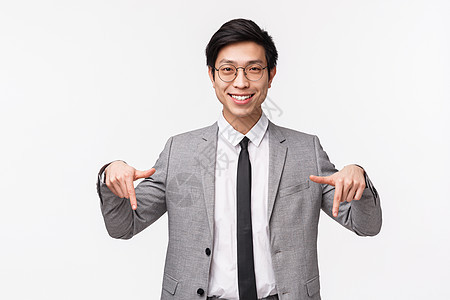 成功聪明专业的年轻亚洲男性办公室经理 企业家介绍项目或演示 建议点击链接 向下指 微笑相机的腰部肖像图片