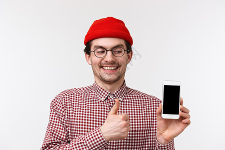 科技与人的概念 近身肖像的怪胎可爱长胡子 笑得开心 看手机显示时微笑快乐 在批准中大拇指 建议使用凉爽应用程序 白背景图片