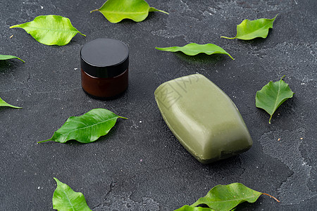 深灰色背景的天然肥皂和绿叶卫生治疗温泉产品皮肤身体树叶坚果薄荷药品图片