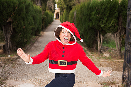 圣诞节和假日概念     快乐的女士有圣诞老人服装粉丝女性季节微笑手套传统花环卷曲女孩假期毛衣图片
