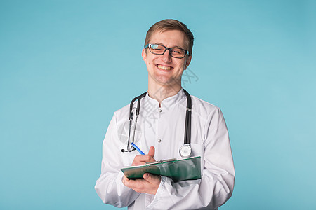 在剪贴板上写字的男性医生肖像 蓝色背景处方保健医院儿科护士职业实验室笔记成人男人图片