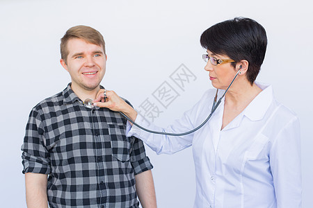 医疗保健 体检 人和医学概念  年轻人和带听诊器的医生在白色背景下听心跳青春期成人呼吸孩子病人从业者药品胸部女性疾病图片