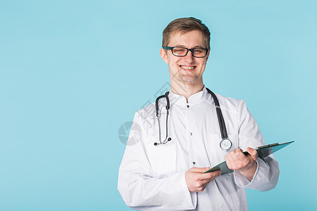 在纸板上写字的男性医生肖像 覆盖蓝色背景和复制空间图片