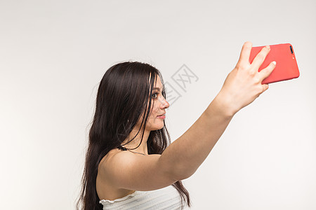 技术和人的概念     年轻女性制作自拍照片 在白色背景上笑脸图片