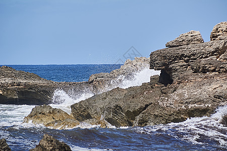 岸边的岩石被波浪撞击力量海景青色泡沫危险娱乐飞溅冲浪海浪碰撞图片