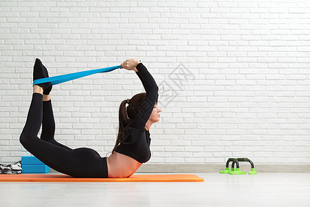 女孩在家中做家务锻炼 以强化她的背部青少年微笑臀部姿势护理运动装重量弓步瑜伽活动图片