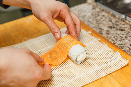 准备 滚动寿司工作鱼片桌子厨师海鲜烹饪美食餐厅木头食物图片