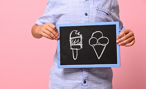 以粉红色背景和复制空间为背景 切割出一个男孩手握黑白板 抽取冰淇淋以及复印空间的画面图片