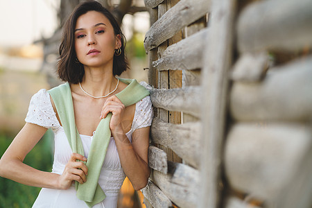 身着白裙子和绿水衣的亚洲妇女 在烟雾干燥棚附近摆姿势国家草地女孩冒充女性快乐绿色农村季节乡村图片