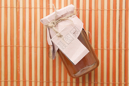 蜂蜜标签装在玻璃罐中的新鲜蜂蜜和纸上空的标签桌子小样营养液体味道广告黄色背景