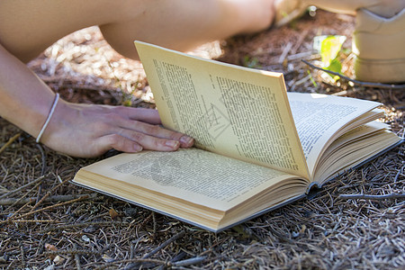 书上的年轻女人的手 在夏天趴在地上图片