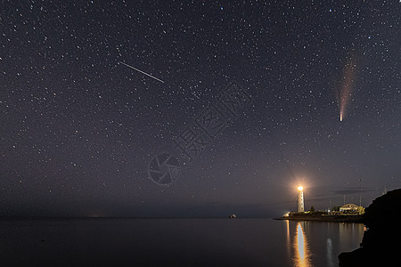 夜晚夜空中白色灯塔上新颖彗星的全景场景星系天空行星天文海滩海洋宇宙蓝色粮食城市图片