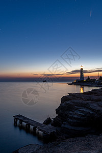 夜晚夜空中白色灯塔上新颖彗星的全景场景天文学支撑地标海滩蓝色行星星座星光望远镜摄影图片