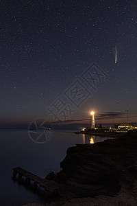 星空上白色灯塔上空新颖彗星的垂直 HDR 風景图片