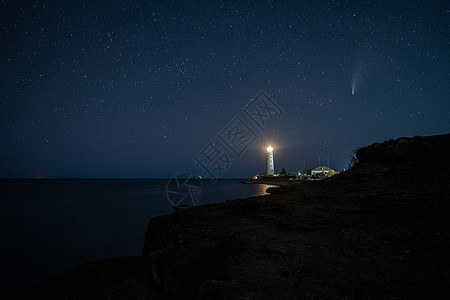 晚间在白色灯塔上空的著名新华丽彗星图片
