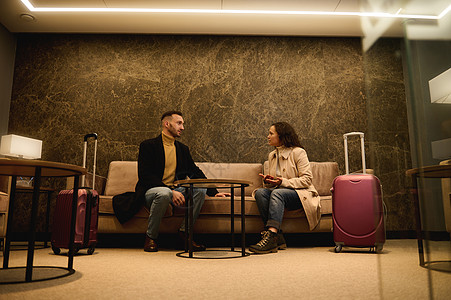 中年帅哥和带手提箱的漂亮女人 出差的商业伙伴在机场候机楼候机时在会议室交谈图片