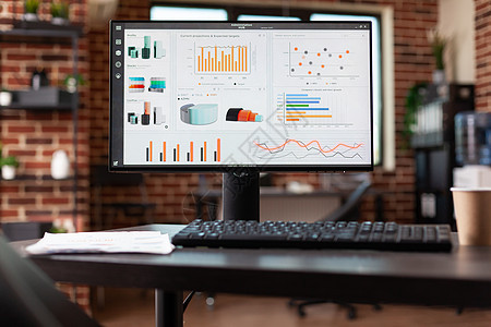 以计算机上的业务分析图表在办公桌的特写图片