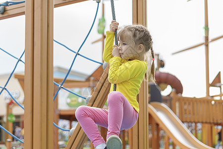 可爱的婴儿玩耍和爬上操场公园风险乐趣女孩行动勇气挑战活动安全摇篮图片